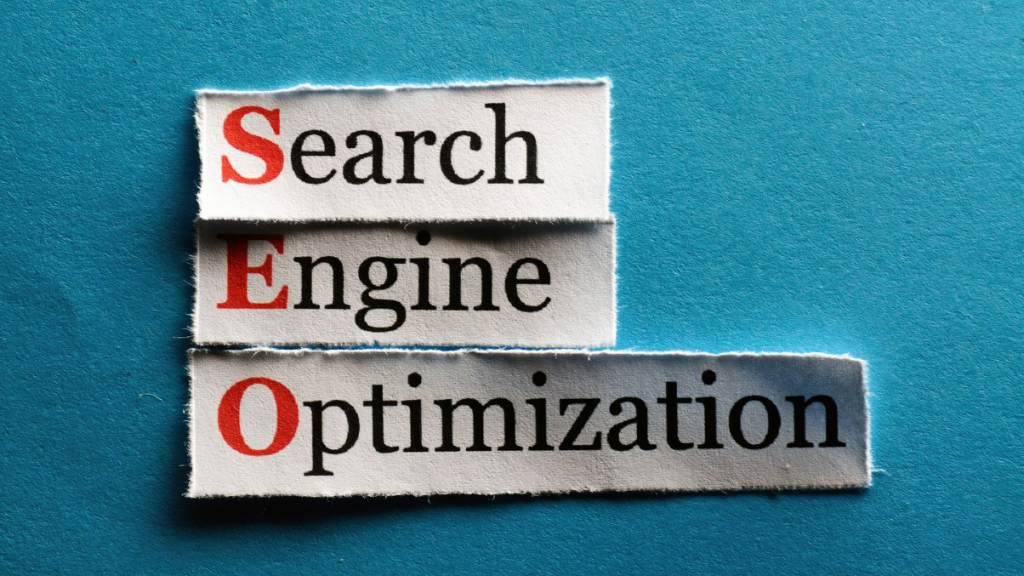 The words "Search," "Engine," and "Optimization" printed on separate strips of paper, with the letters "SEO" highlighted in red.