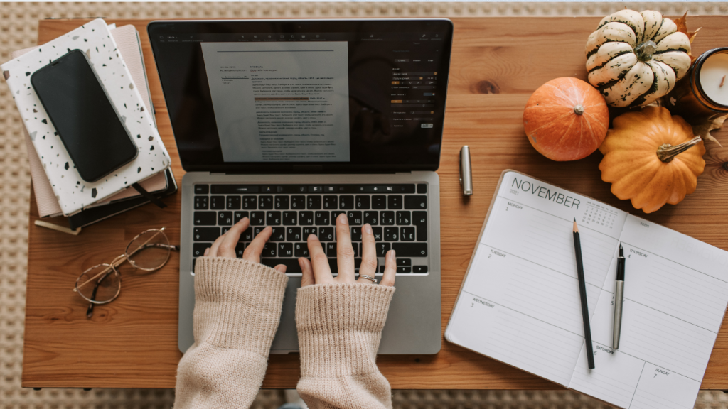 A chiropractic marketing specialist writing an SEO blog post and planning the November content calendar on a laptop, proving expertise and generating leads.